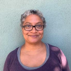 Doris Robinson smiles at the camera wearing purple.