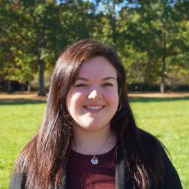 Alyssa O’Brien looks at the camera, she is standing outside in the sun.