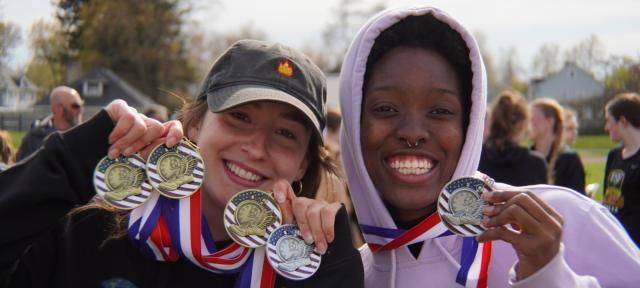 Womens Track and Field winners hold up awards