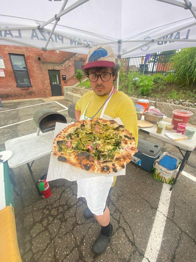 Will Meyer holds out a vegan pizza.