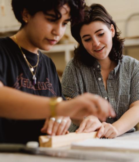 Two students work together in an art studio.