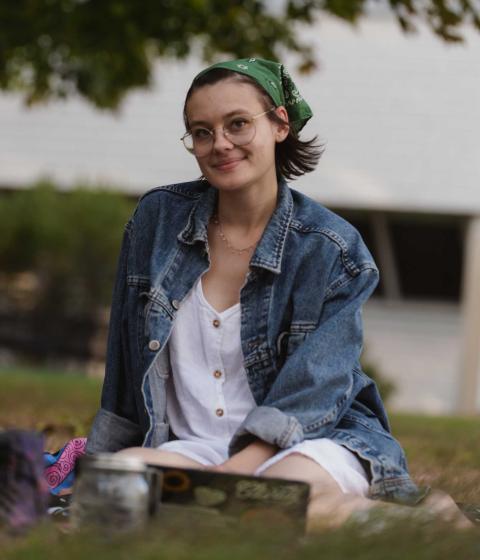 Student sitting outside on the lawn.