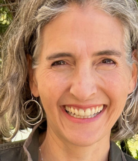 Lise Sanders smiling at the camera. She is standing outdoors.